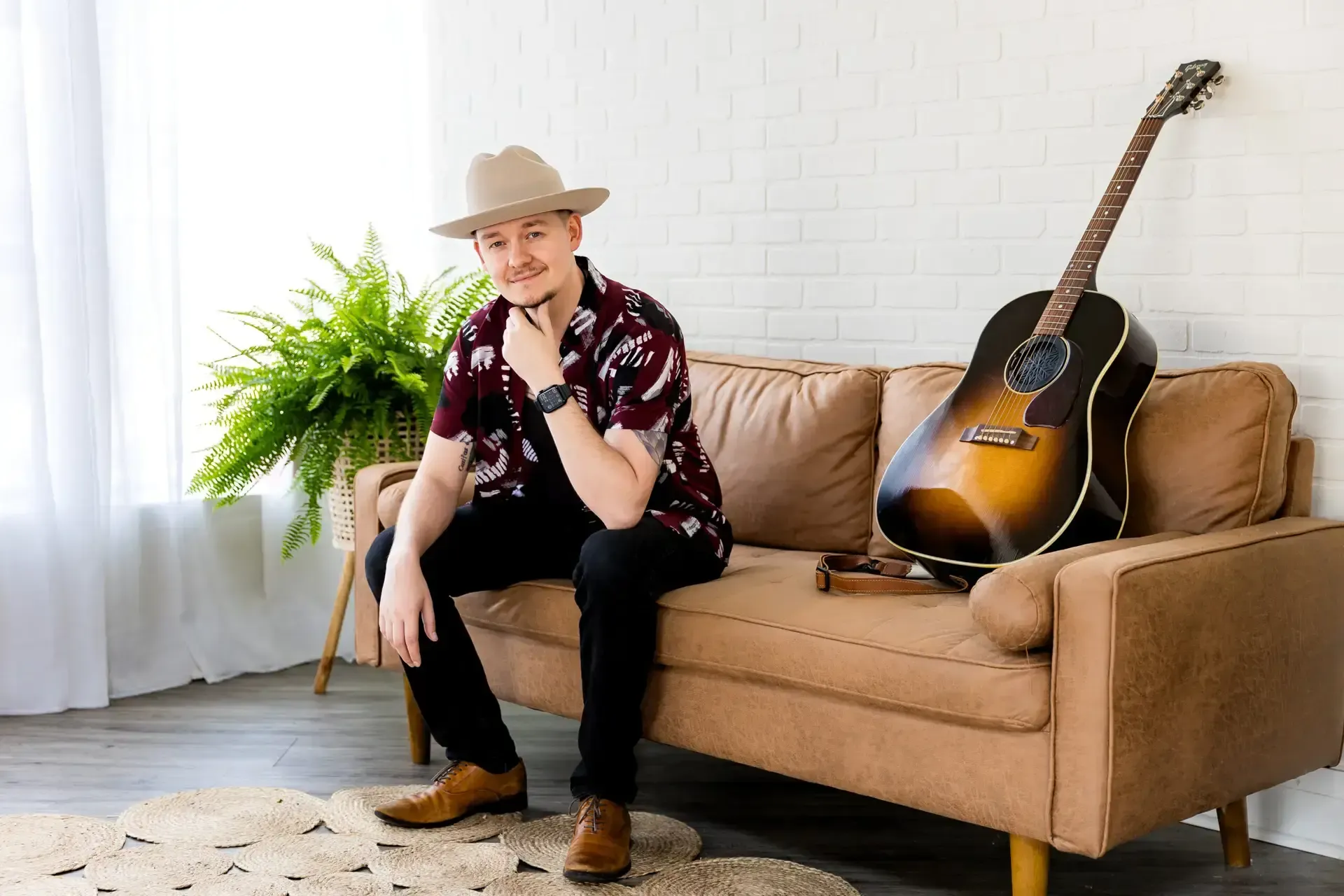 Daniel seated beside his guitar